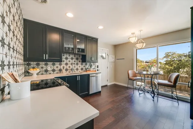 a large white kitchen with lots of counter space and breakfast area
