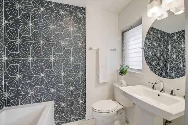 a bathroom with a sink a toilet and a mirror