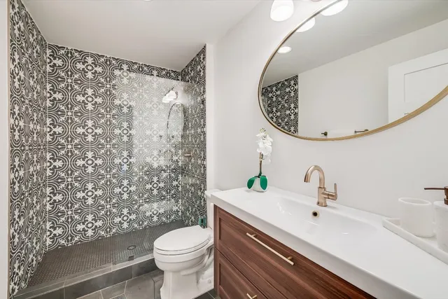 a bathroom with a sink a toilet and a mirror