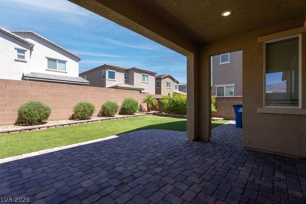 7126 Calvert Cliffs Street North Las Vegas, NV 89084 - Photo 37 of 44 A spacious covered patio with pavers transitions to a well-maintained yard, ideal for outdoor leisure.