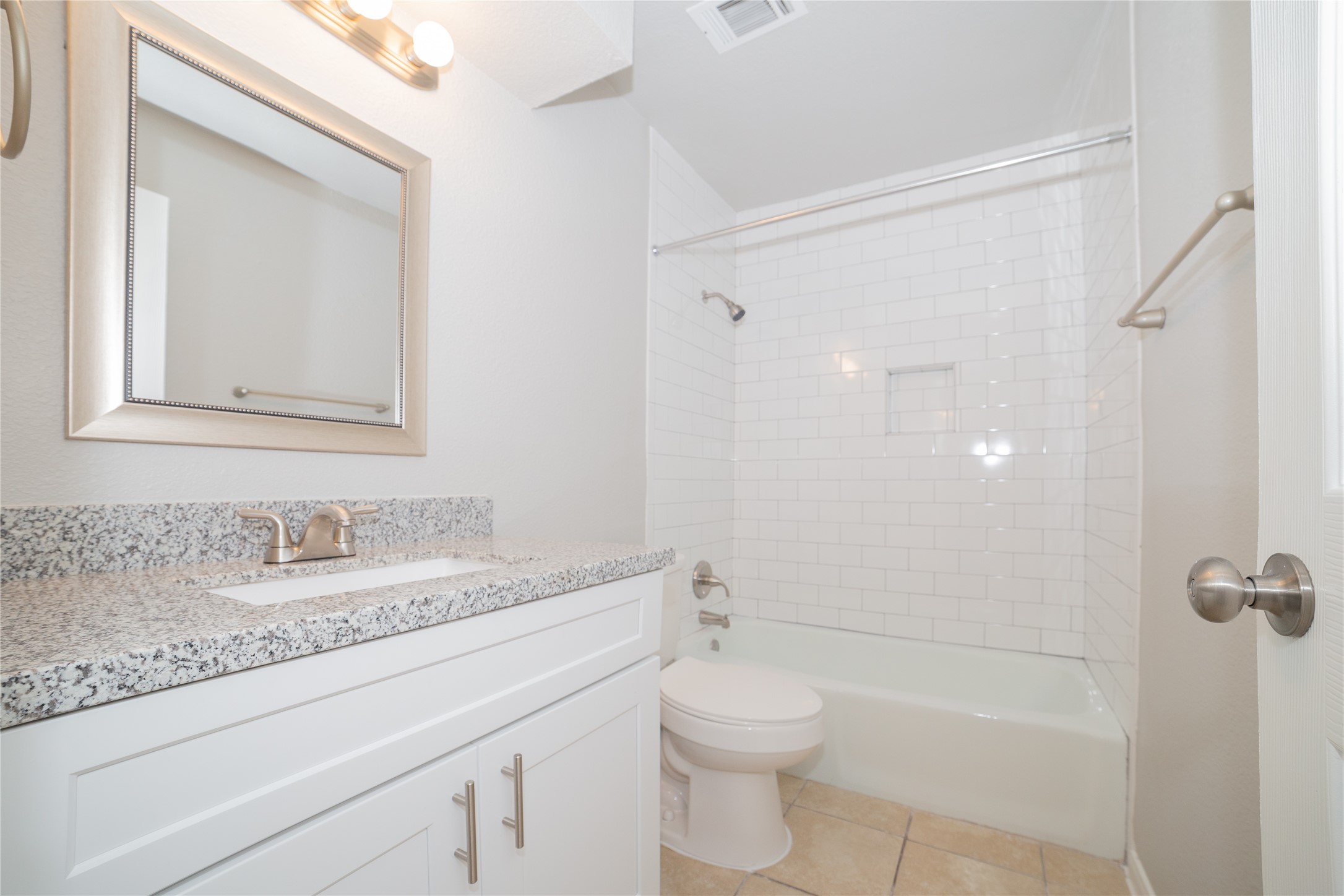 2010 North Travis Street, Unit 116 Liberty, TX 77575 - Photo 1 of 11 a bathroom with a granite countertop sink a toilet and shower