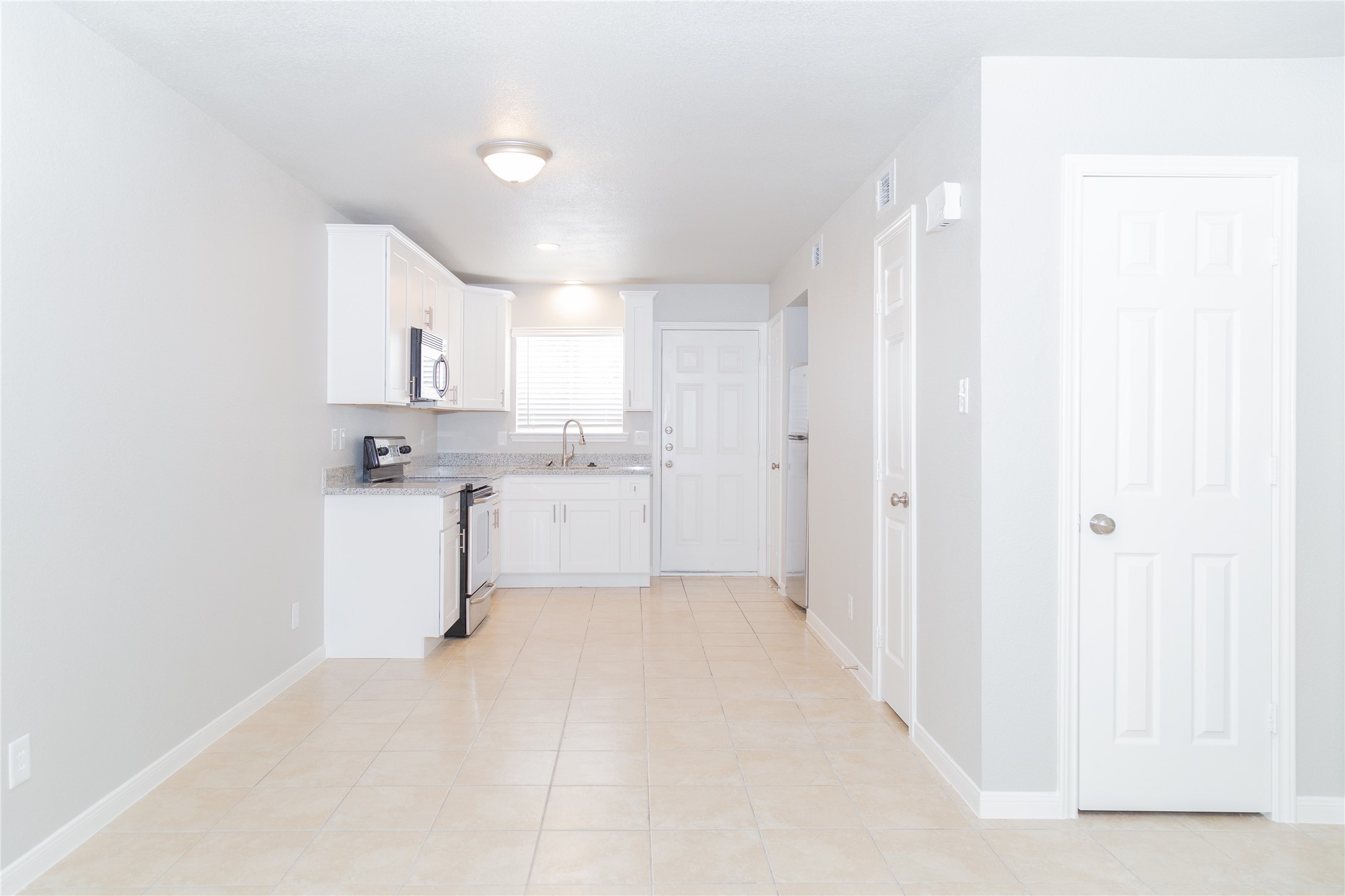 2010 North Travis Street, Unit 116 Liberty, TX 77575 - Photo 2 of 11 a view of a kitchen with white cabinets