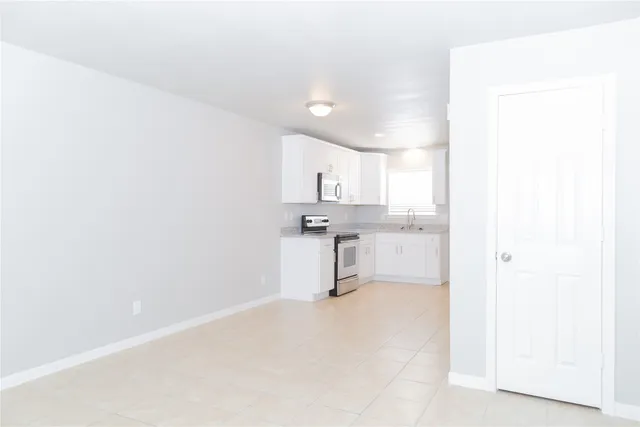 a view of a kitchen with white cabinets and a sink