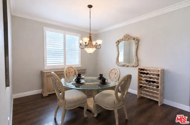 a dining room with furniture a chandelier and wooden floor
