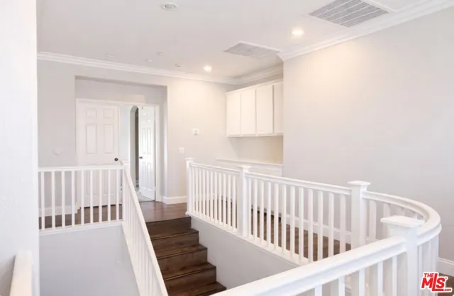 a view of a hallway with wooden floor and windows