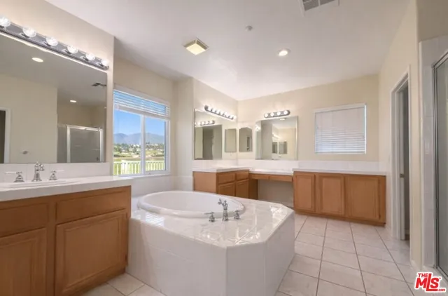a bathroom with a tub sink and mirror