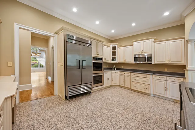 a kitchen with stainless steel appliances granite countertop a refrigerator and a stove top oven