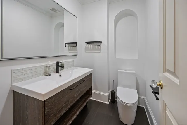 a bathroom with a toilet sink and mirror