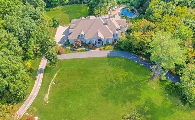 an aerial view of residential houses with outdoor space and trees