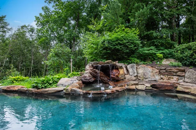 a view of a lake with lawn chairs under an umbrella
