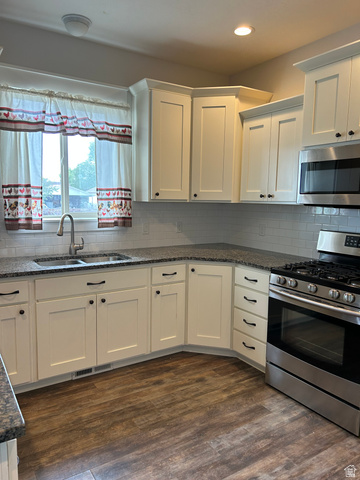 175 North 100th West Centerfield, UT 84622 - Photo 13 of 32 Modern kitchen featuring wood-finish flooring, white cabinetry, dark countertops, a stainless steel range, and a subway tile backsplash