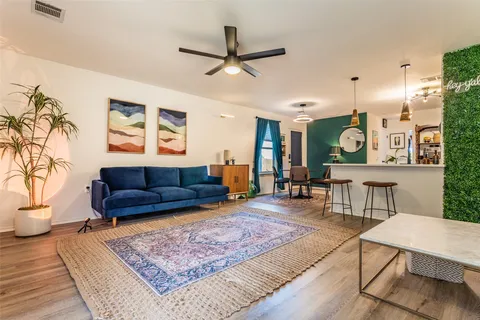 a living room with furniture and a wooden floor
