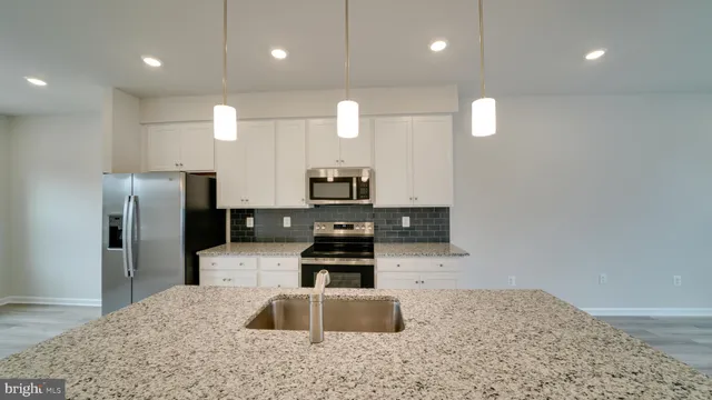 a view of a kitchen with wooden floor and electronic appliances
