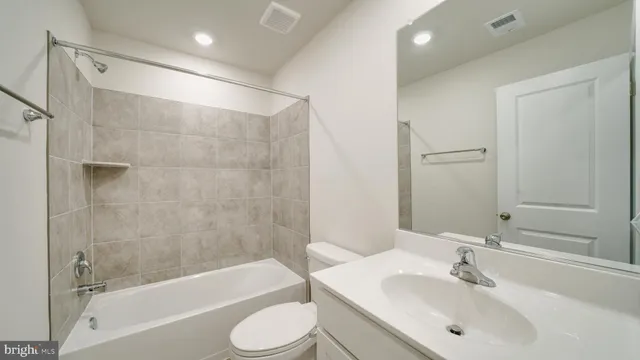 a bathroom with a bathtub shower sink vanity and toilet