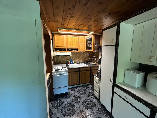 a kitchen with stainless steel appliances granite countertop a refrigerator and a stove top oven