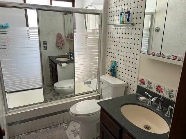 a bathroom with a sink toilet and shower