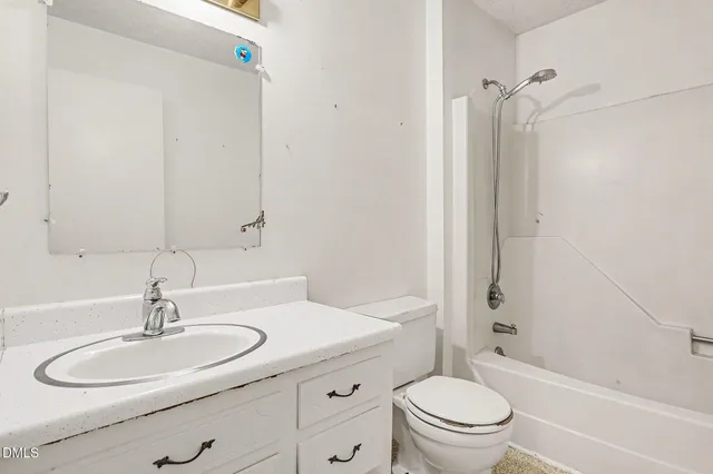 a bathroom with a granite countertop sink toilet a mirror and shower