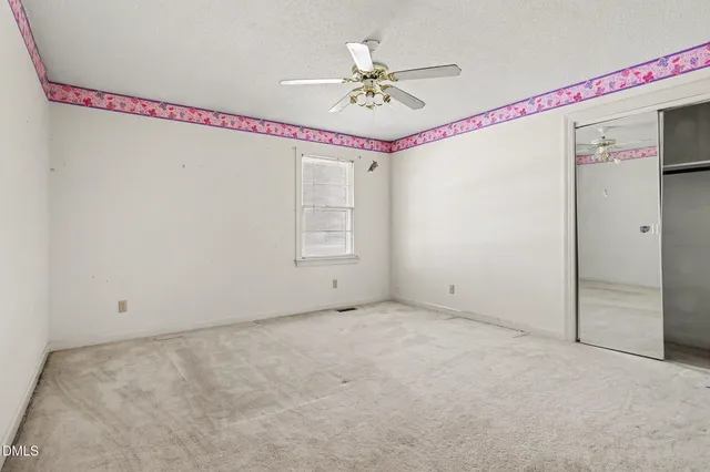 a view of a hallway with a ceiling fan