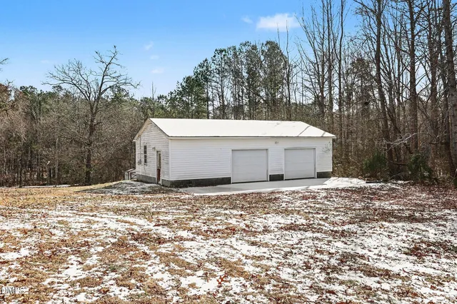 a white house that has tree in front of it
