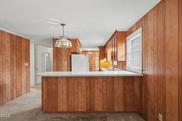 a view of kitchen with wooden floor and cabinets