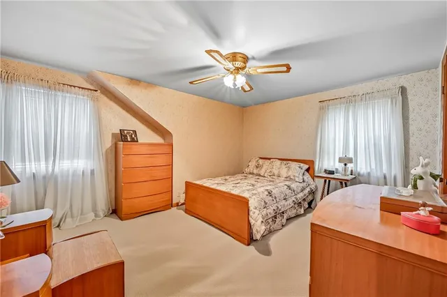 a bedroom with a bed and dresser with mirror