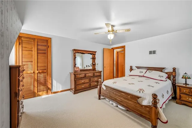 a bedroom with a bed a dresser and a chandelier