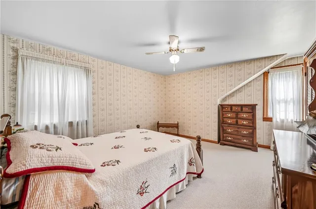 a bedroom with a bed a dresser and a chandelier