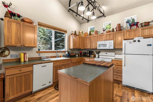 a kitchen with stainless steel appliances granite countertop a sink a stove and a refrigerator