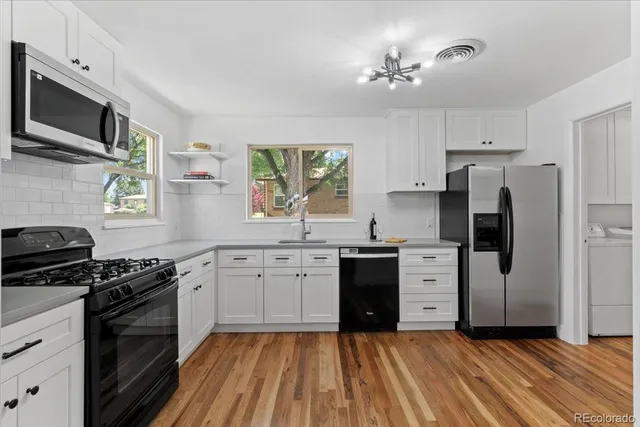 a kitchen with stainless steel appliances a stove a sink and a refrigerator