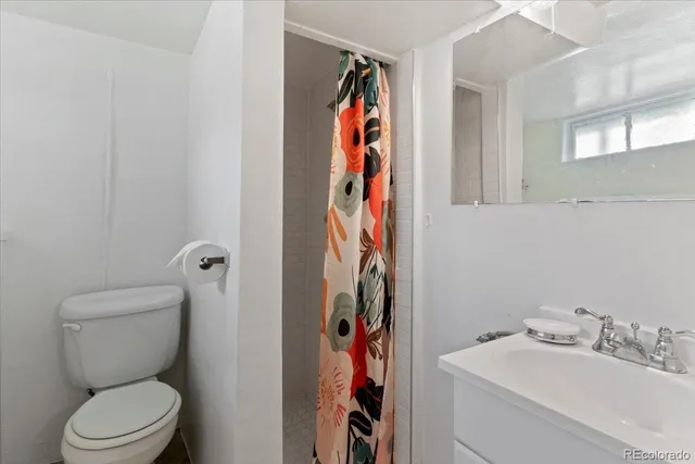 a bathroom with a toilet sink and shower curtain