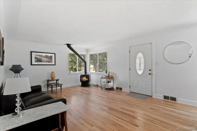 a living room with furniture a desk and chair with wooden floor