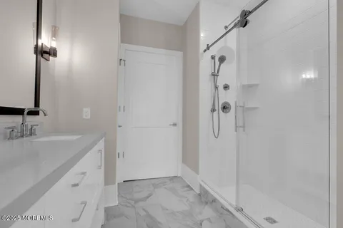 a bathroom with a double vanity sink a mirror and a shower