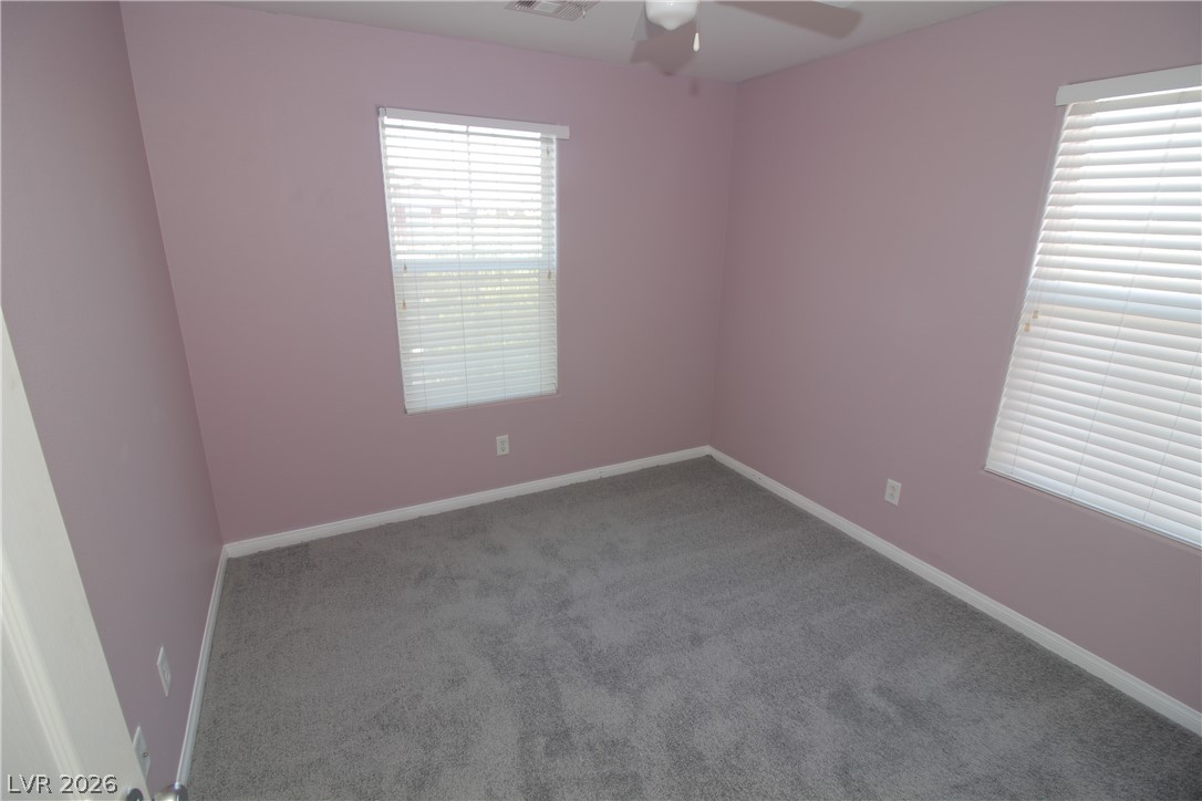 9289 Valley Ranch Avenue Las Vegas, NV 89178 - Photo 26 of 29 A comfortable bedroom with soft pink walls and light gray carpet.