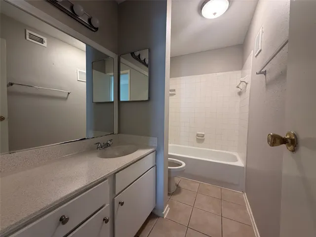 a bathroom with a granite countertop sink a toilet and shower