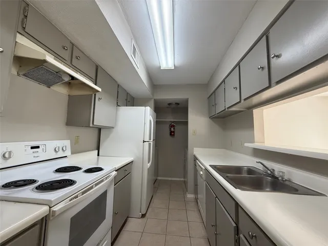 a kitchen with stainless steel appliances a sink a stove and a refrigerator