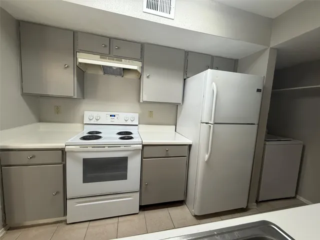 a white refrigerator freezer and a stove sitting inside of a kitchen