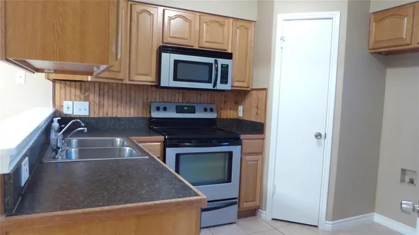 a kitchen with kitchen island granite countertop a sink and a stove top oven