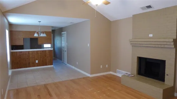 an empty room with wooden floor and fireplace