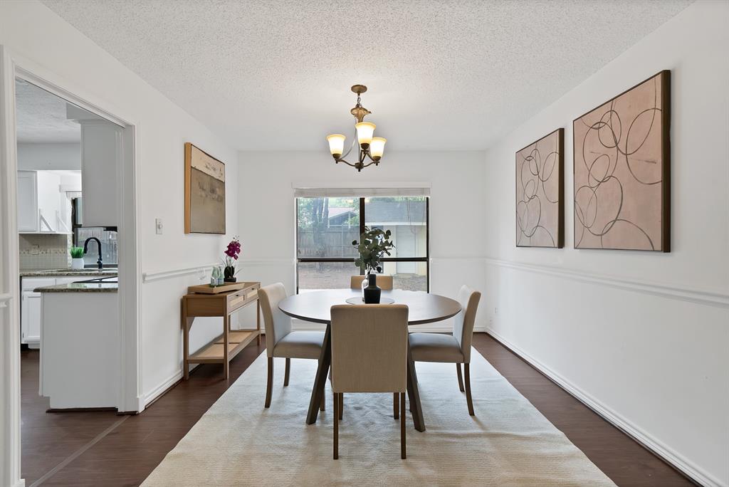 413 Wild Oak Lane Euless, TX 76039 - Photo 11 of 29 a dining room with wooden floor a chandelier a wooden table and chairs