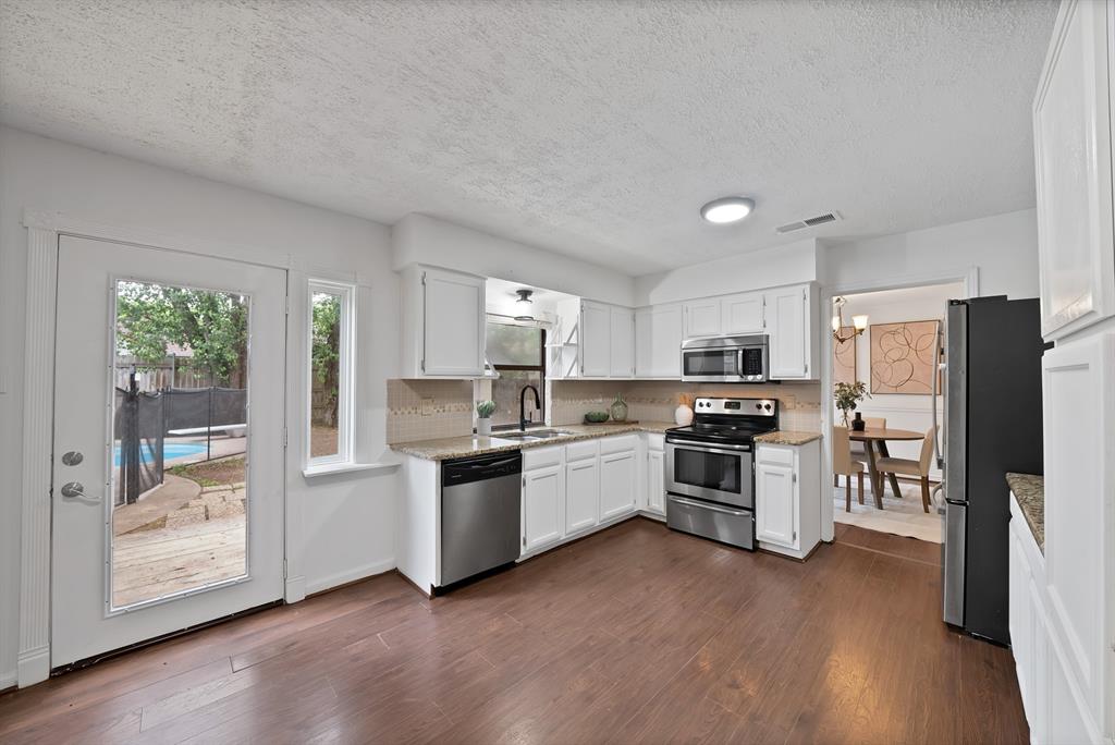 413 Wild Oak Lane Euless, TX 76039 - Photo 7 of 29 a kitchen with a refrigerator a stove top oven a sink and a potted plant