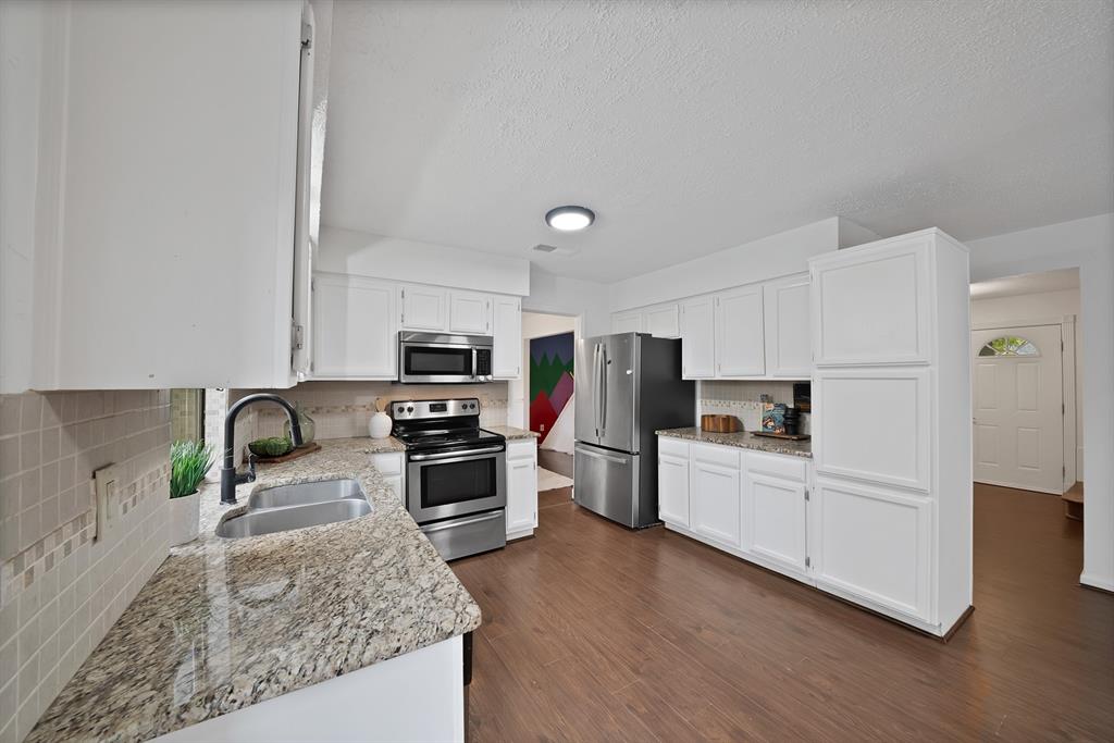 413 Wild Oak Lane Euless, TX 76039 - Photo 8 of 29 a kitchen with granite countertop a stove top oven and refrigerator