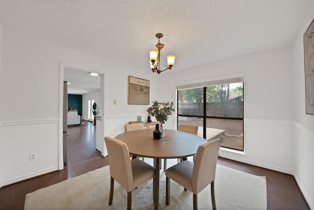 413 Wild Oak Lane Euless, TX 76039 - Photo 10 of 29 a dining room with wooden floor a chandelier a wooden table and chairs