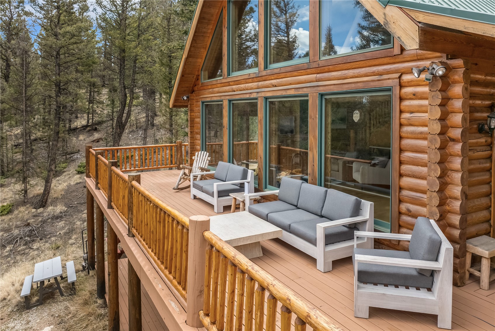999 Bowstring Como, CO 80456 - Photo 32 of 37 a view of a patio with couches table and chairs with wooden floor and fence