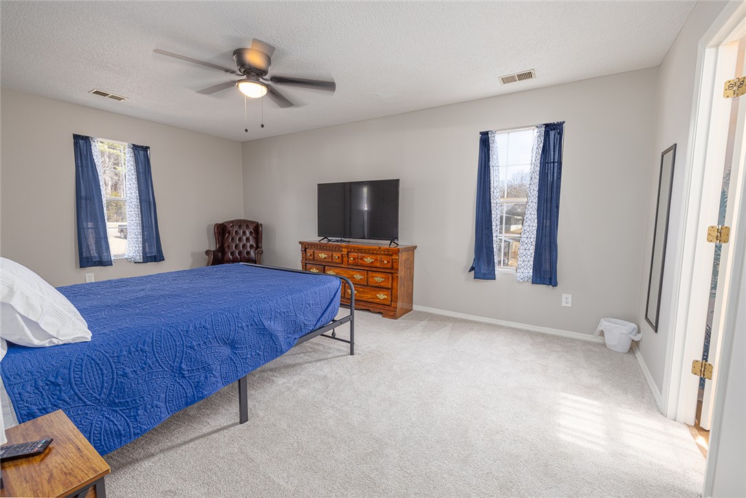 410 South Cove Road Seneca, SC 29672 - Photo 25 of 25 This spacious bedroom offers ample natural light and comfortable carpeted flooring, perfect for relaxation.