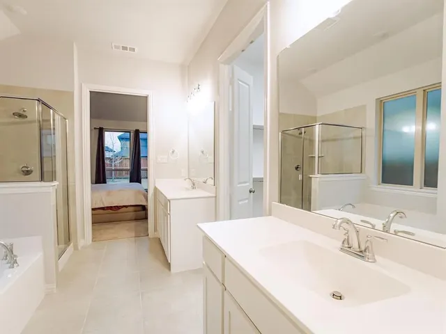 a en suite bathroom with a double vanity sink and mirror