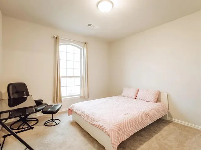 a bedroom with a bed chair and window
