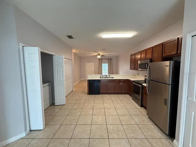 a view of a kitchen with a sink and a refrigerator