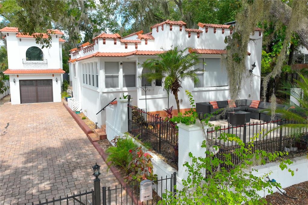 a view of a white house with a small yard and plants