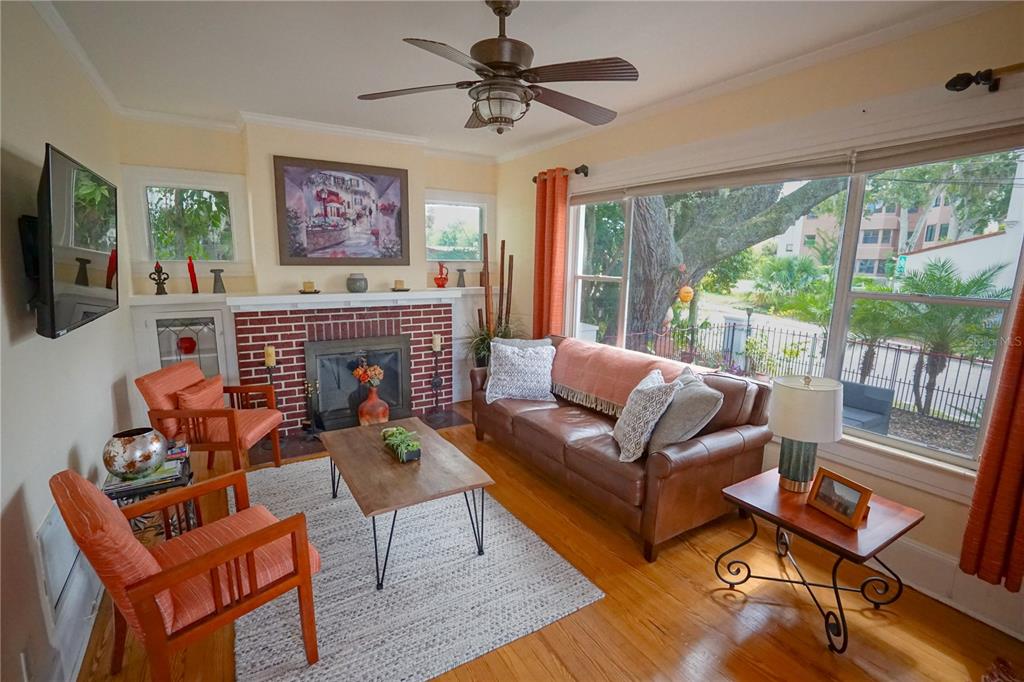 229 East 6th Avenue Mount Dora, FL 32757 - Photo 4 of 65 a living room with furniture a flat screen tv and a fireplace