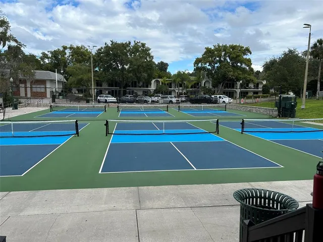 a kitchen with stainless steel appliances kitchen island granite countertop a refrigerator a stove and white cabinets with wooden floor